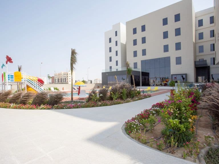 The hotel exterior with landscaped gardens and the children's play area