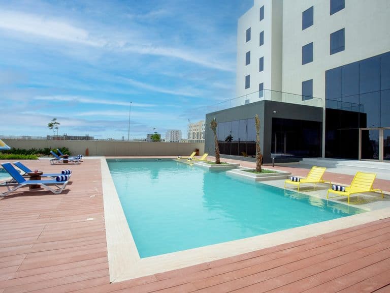 The swimming pool with the hotel behind it
