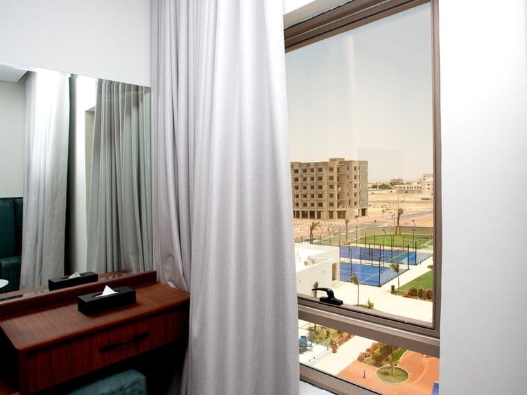 A room window overlooking the pool and padel courts