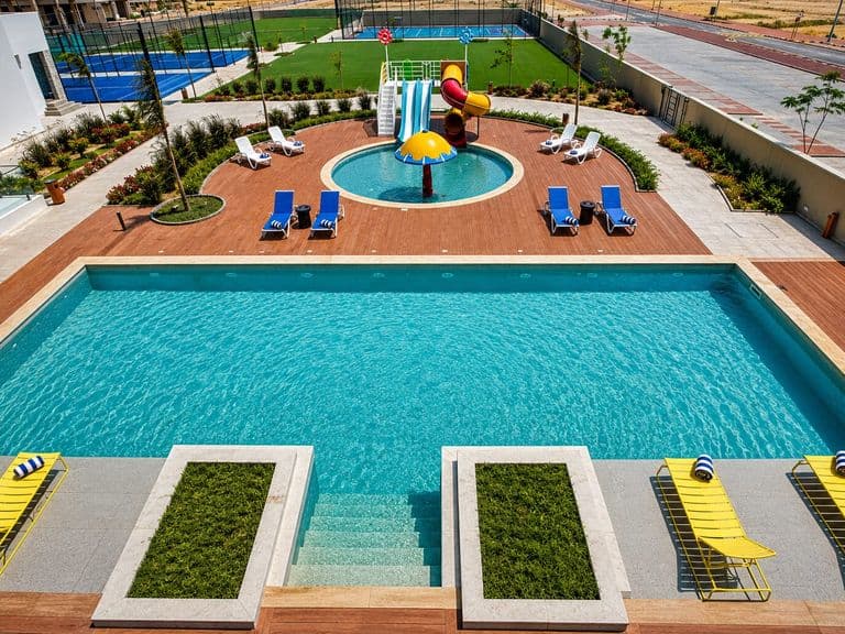 The main swimming pool from above, with the children's pool, water slides and sports courts behind it
